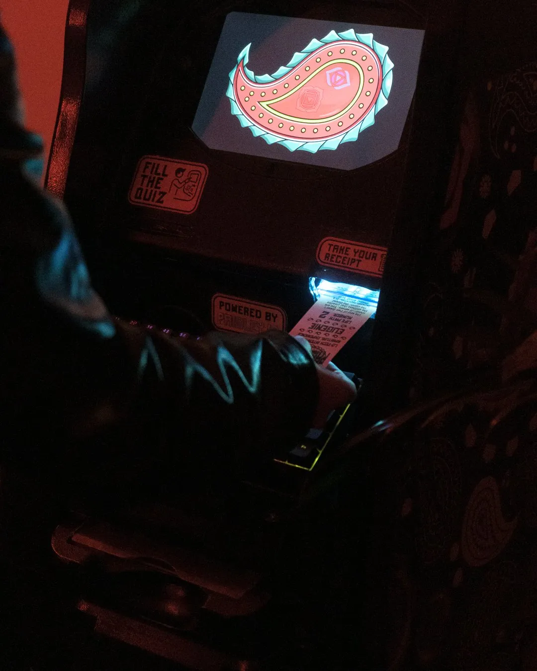 An AFTM screen glowing with a paisley while a fortune ticket prints