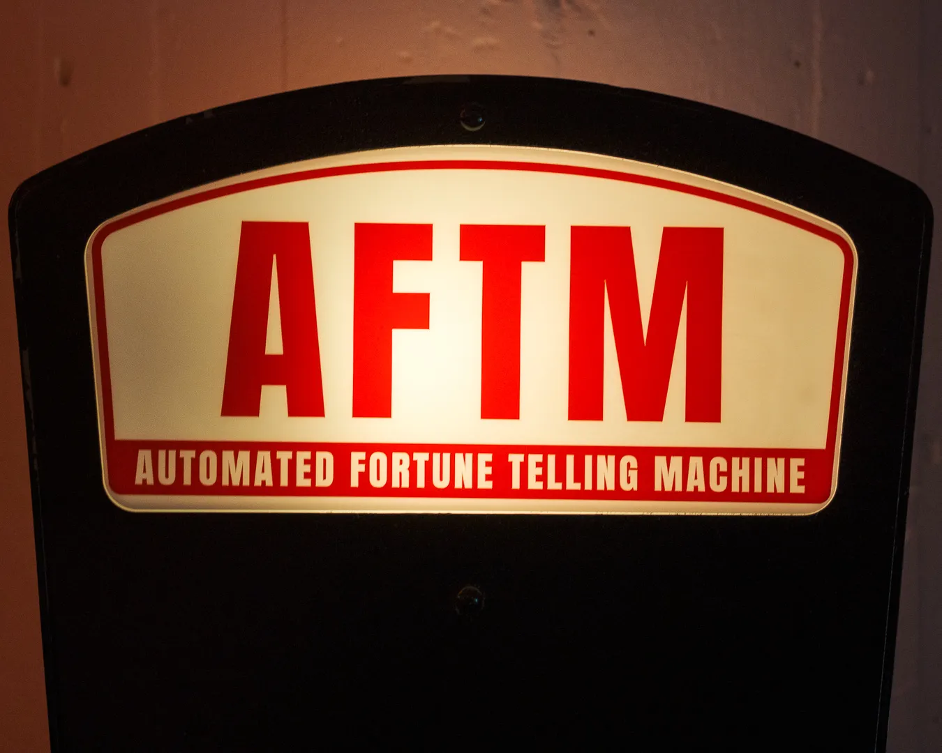 The lit AFTM sign, Automated Fortune Telling Machine, seen straight on