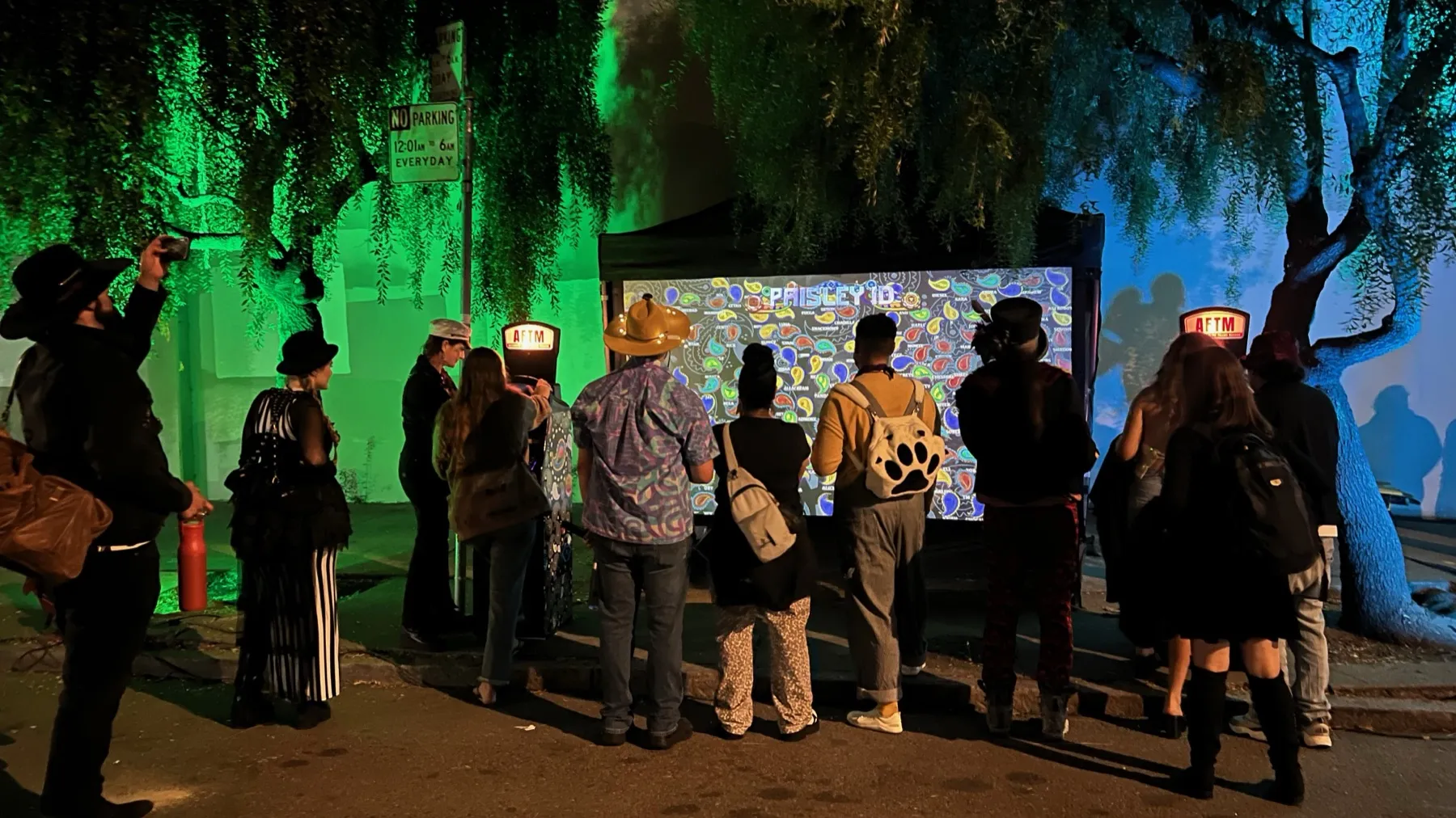 A crowd at night in front of the aquarium screen, an AFTM on each side