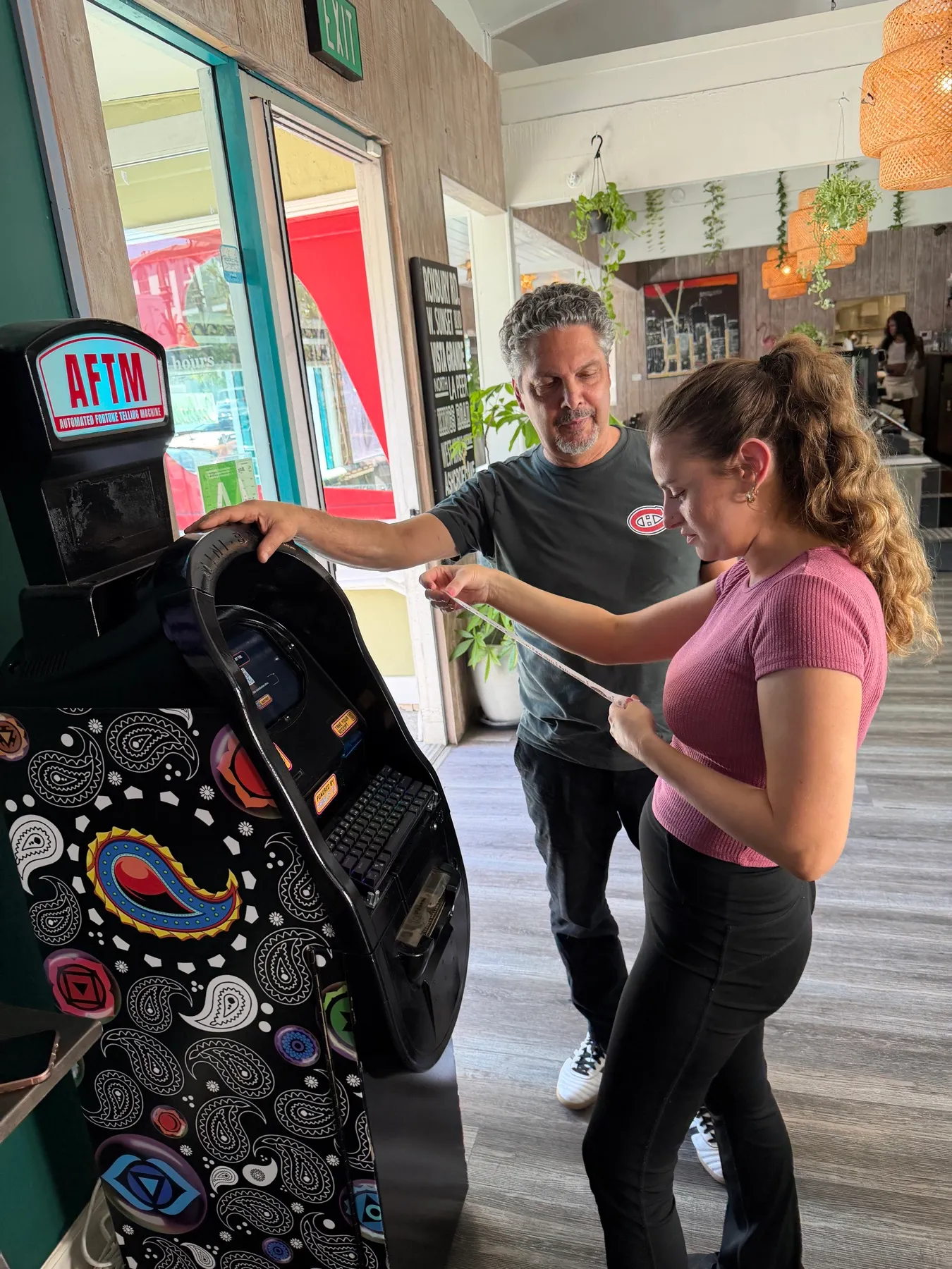 The owner of Attitude Café showing a guest her printed fortune