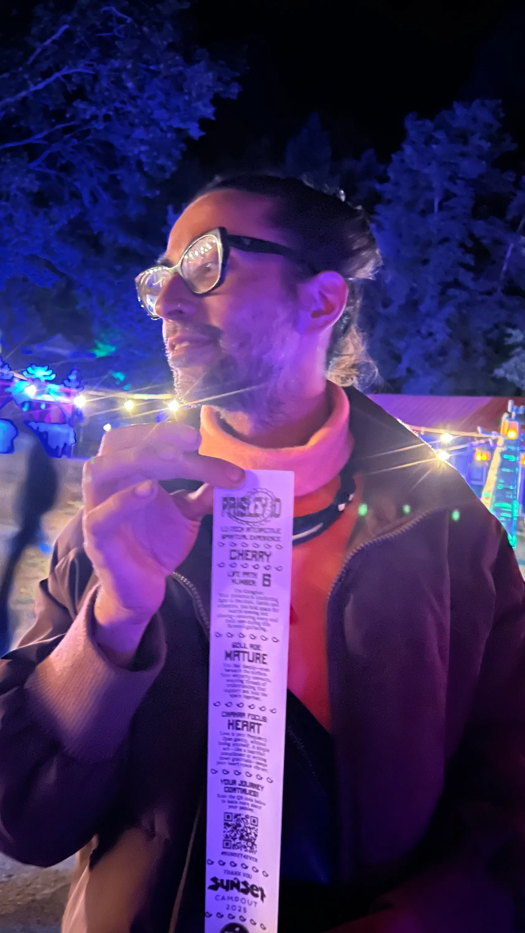 A guest reading his fortune ticket under the trees